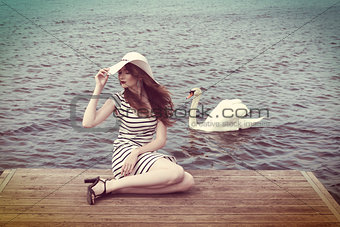 cute girl with hat and near a swan . vintage color