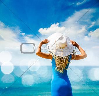 Woman in Blue Dress and Hat at Sea. Back View.