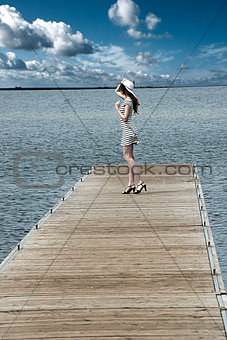 dreaming girl in elegat dress on lakes pier . HDR effect