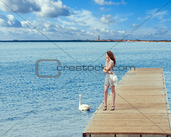 girl on pier with swan
