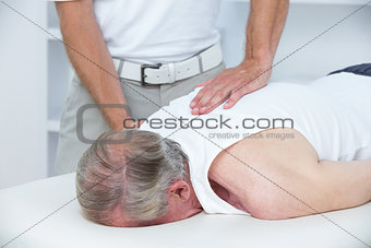 Physiotherapist doing shoulder massage to his patient