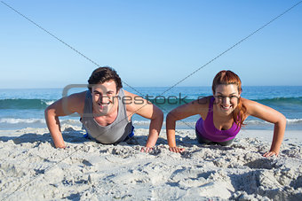 Happy couple doing push ups together