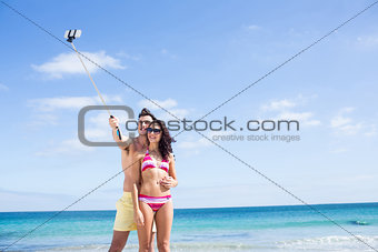 Happy couple taking selfie with selfie stick