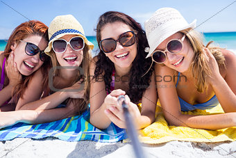 Happy friends wearing sun glasses and taking selfie