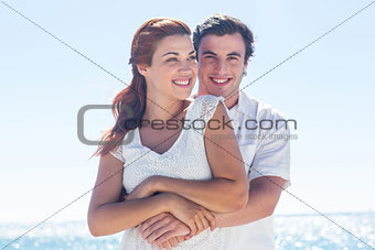 Happy couple hugging and looking at camera