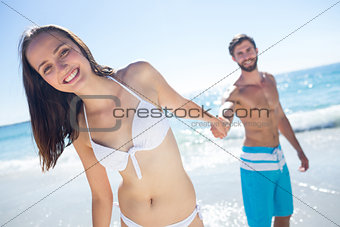 Smiling couple holding hands and looking at camera