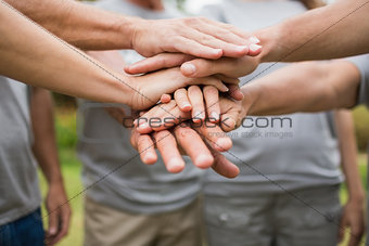 Happy volunteer family putting their hands together