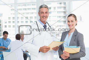 Male and female doctors working on reports