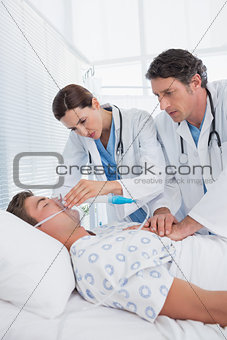 Worried doctors doing heart massage and holding oxygen mask