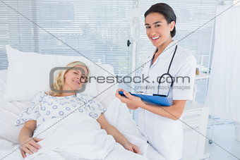 Smiling doctor standing next to her patient