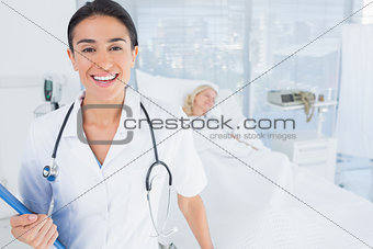 Smiling doctor looking at camera in patients room
