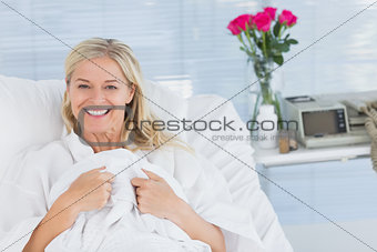 Smiling patient looking at camera on her bed