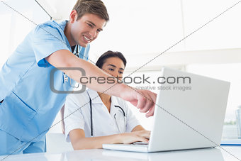 Doctors working with laptop computer