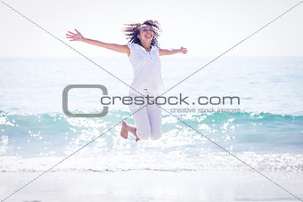 Carefree woman jumping on the beach