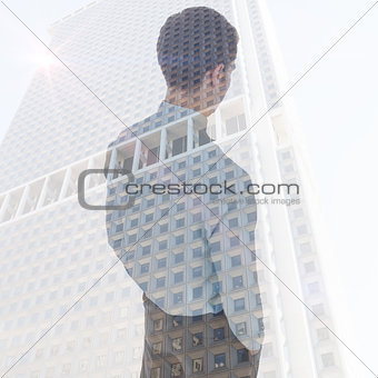 Composite image of businessman standing with hands in pockets