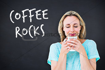 Composite image of cheerful blonde holding mug of hot drinking