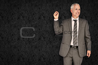 Composite image of businessman holding marker