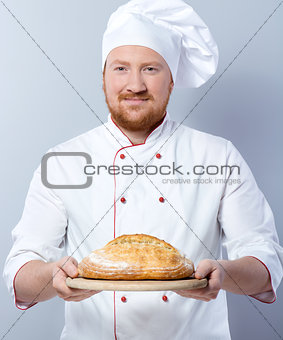 Head-cook holding freshly baked bread
