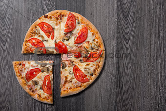 Top view of delicious Italian pizza with ham and tomatoes 