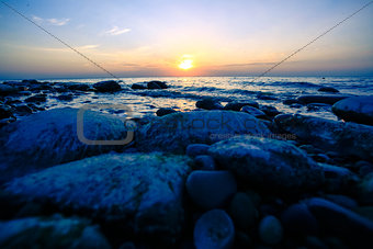 Amazing Sunset over the coast of pebble ocean