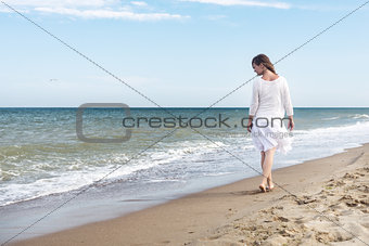 Woman in summer dress standing on a sea