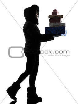 woman winter coat walking carrying christmas gifts silhouette