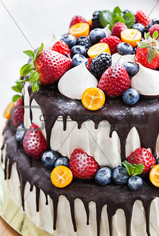 Cake with icing, decorated with fresh fruit