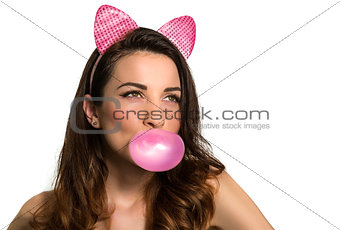 Hot playful brunette model blowing pink chewing bubble gum looki