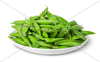 Big pile of green peas in pods on white plate
