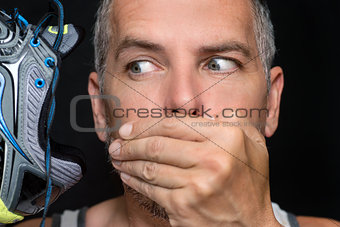 Man Covers Mouth After Smelling Shoe