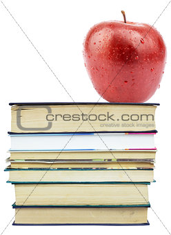 Fresh apple on pile of books