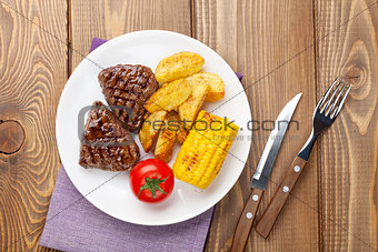 Steak with grilled potato, corn and tomato