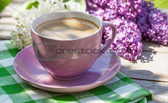 Coffee cup and colorful lilac flowers