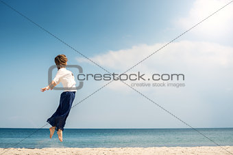 Young woman jumping on the beach