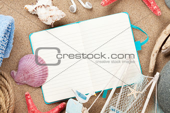 Travel and vacation notepad with items over sand