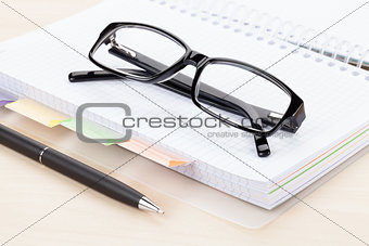 Office table with glasses over notepad