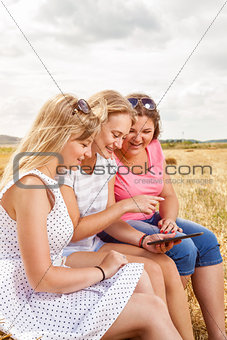Group of friends outdoors with a tablet