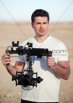 Videographer with steadicam equipment on the beach