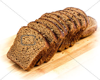 Cut slices of rye bread with caraway seeds on a wooden board