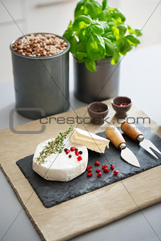 Camembert cheese with fresh herbs, pomegranate, and peppercorns