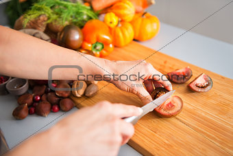 Closeup of woman's hands holding and slicing tomato