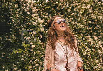 bohemian young woman among flowers looking up on copy space