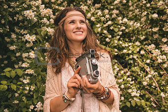 bohemian young woman with retro camera looking up on copy space