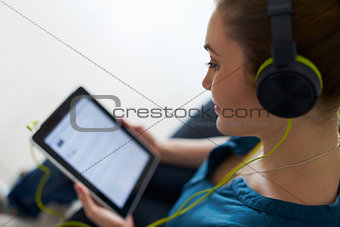 Woman With Green Headphones Listens Podcast Music On Tablet PC