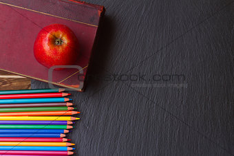Set of colorful pencils on black board
