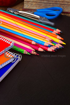 Set of colorful pencils on black board