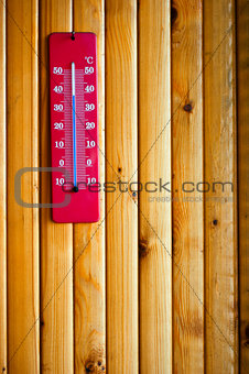 Thermometer heat on wood background