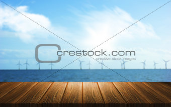 3D background of a wooden table looking out to a wind farm in th