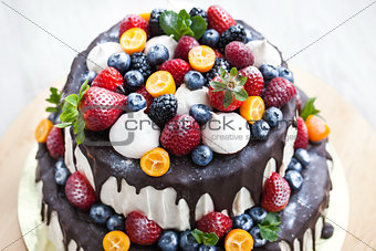 Cake with icing, decorated with fresh fruit