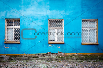 Three windows on a blue wall